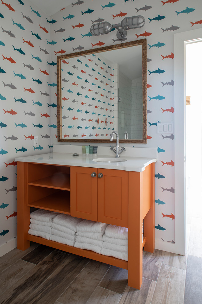 Photo of a mid-sized midcentury kids bathroom in Other with recessed-panel cabinets, orange cabinets, a corner shower, white walls, ceramic floors, an undermount sink, quartzite benchtops, brown floor, a hinged shower door and white benchtops.