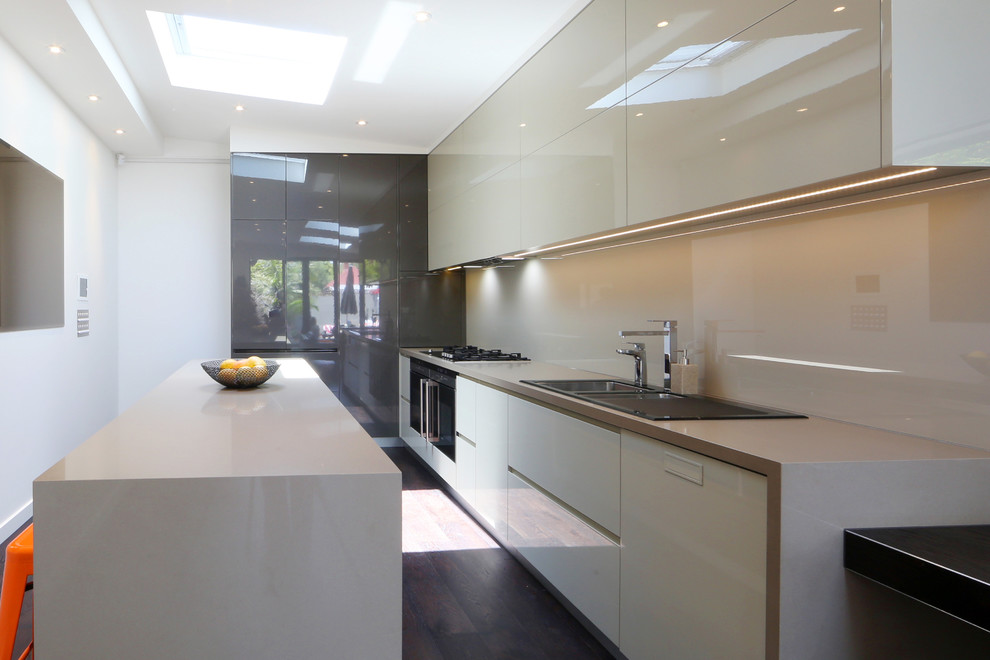 Inspiration for a contemporary l-shaped eat-in kitchen in Melbourne with an undermount sink, flat-panel cabinets, white cabinets, quartz benchtops, glass sheet splashback and stainless steel appliances.