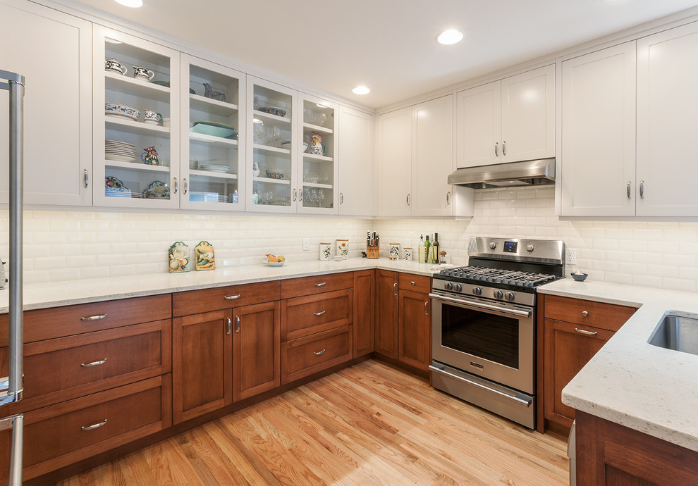 Transitional light wood floor kitchen photo with a double-bowl sink, shaker cabinets, quartz countertops, white backsplash, subway tile backsplash and stainless steel appliances