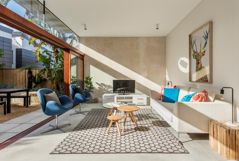 Photo of a contemporary open concept living room in Sydney with concrete floors and a freestanding tv.
