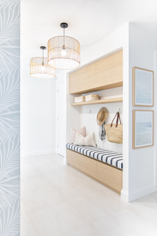 This is an example of a mid-sized beach style mudroom in Gold Coast - Tweed with white walls, a single front door, a white front door and beige floor.