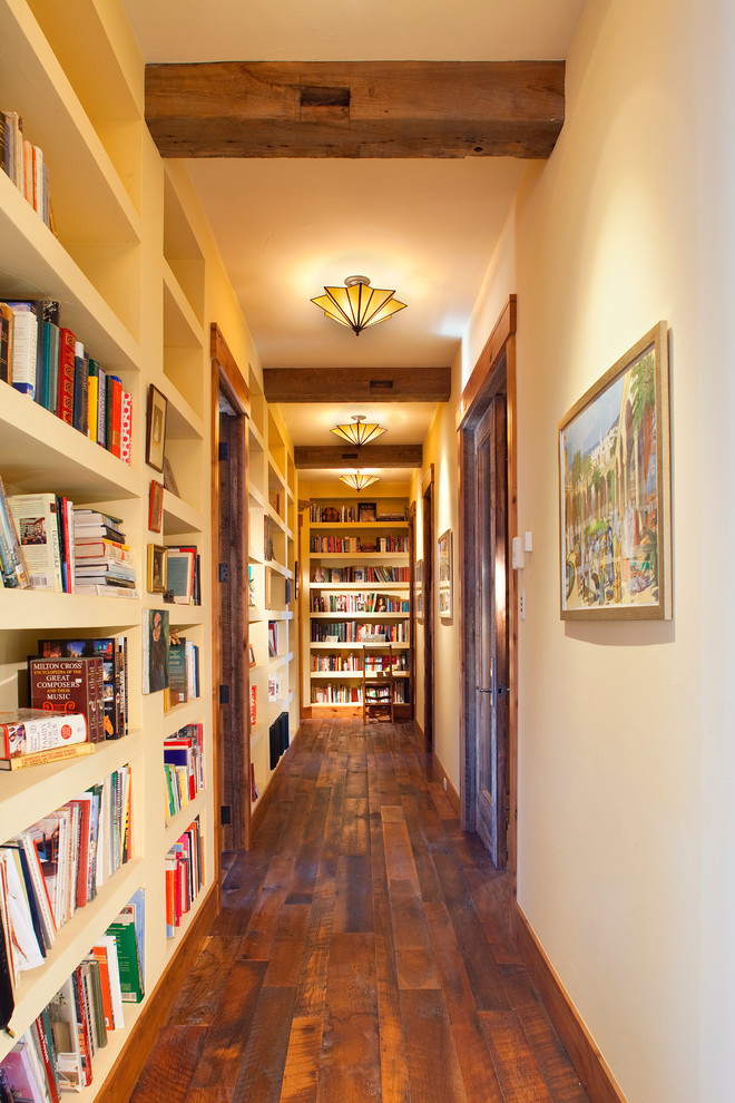Example of a mountain style dark wood floor hallway design in Denver with white walls