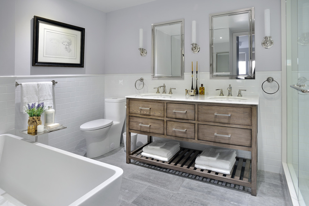 This is an example of a small transitional 3/4 bathroom in Toronto with medium wood cabinets, a freestanding tub, a one-piece toilet, white tile, ceramic tile, grey walls, marble floors, an undermount sink, quartzite benchtops, white benchtops and flat-panel cabinets.