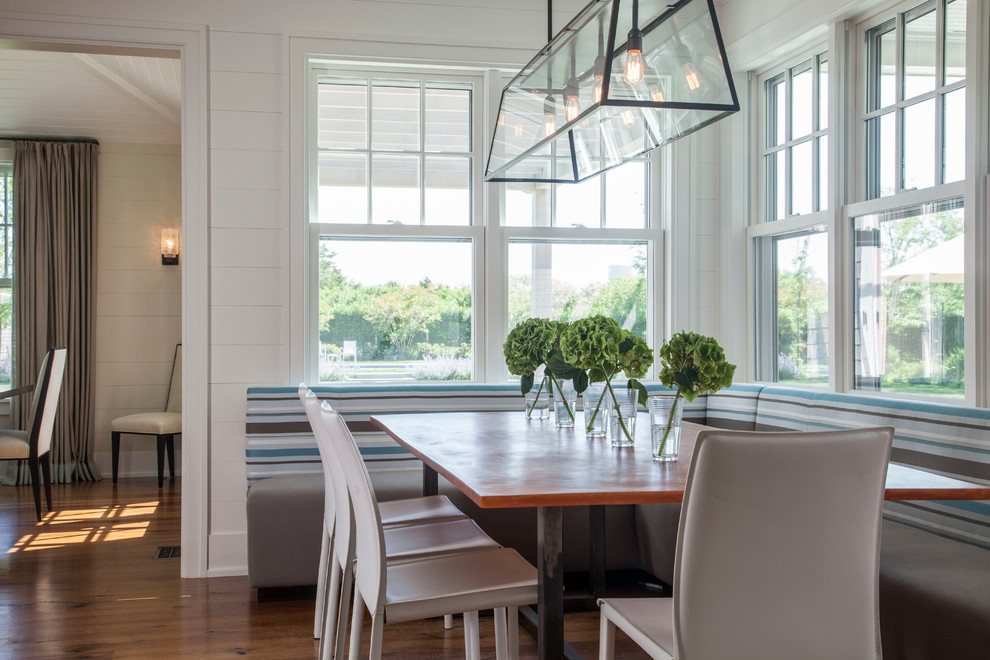 Design ideas for a beach style dining room in Boston with white walls, medium hardwood floors and no fireplace.