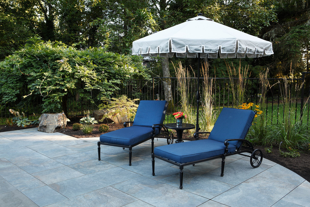 Inspiration for a large contemporary backyard patio in Seattle with a fire feature, tile and an awning.