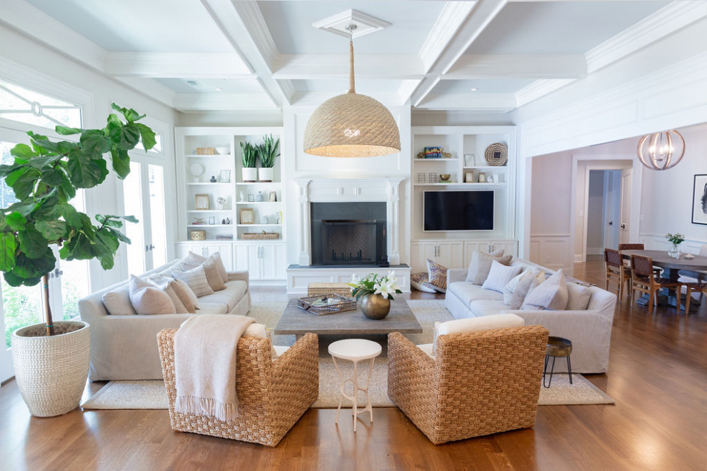 Design ideas for a mid-sized transitional living room in Boston with white walls, medium hardwood floors, a standard fireplace, a built-in media wall and brown floor.