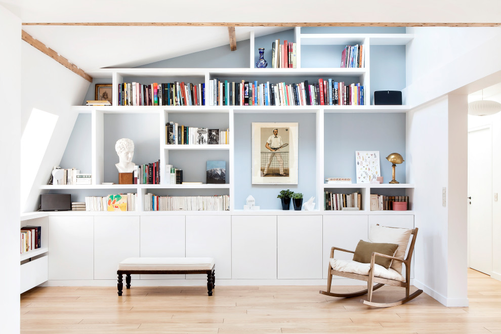 Imagen de sala de estar abierta actual con paredes blancas, suelo de madera clara y suelo marrón