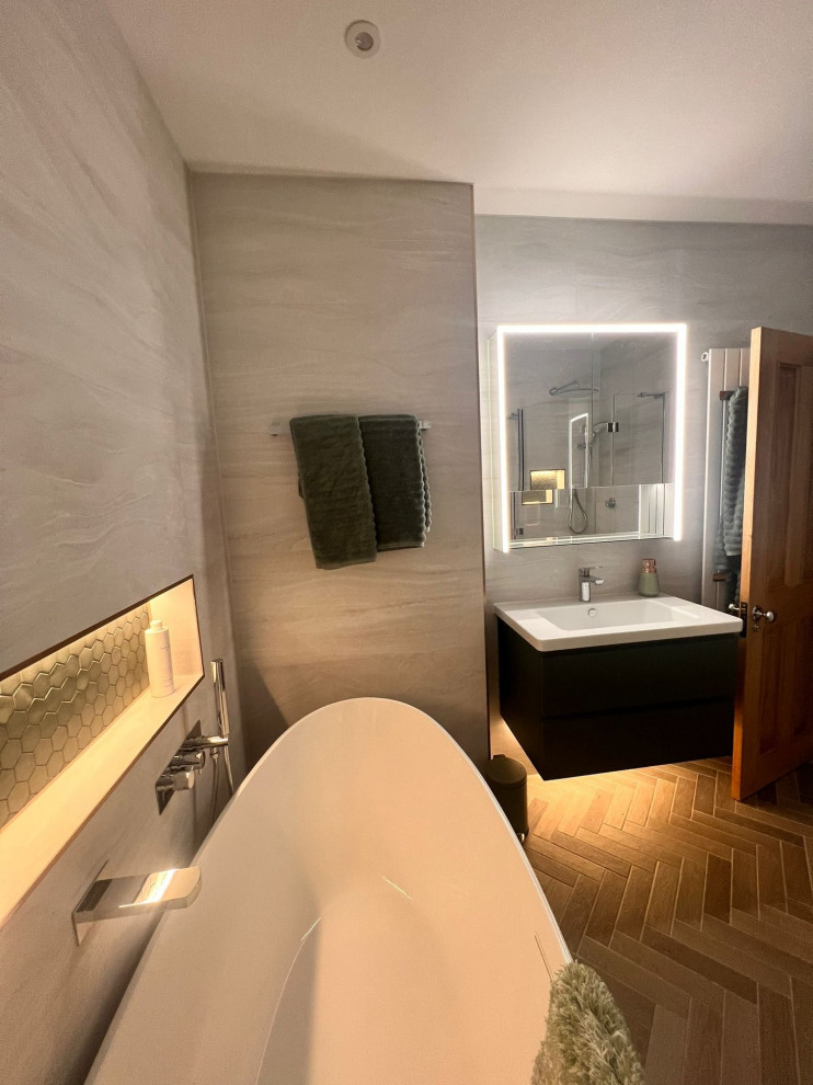 Mid-sized modern bathroom in Surrey with a corner shower, a wall-mount toilet, gray tile, grey walls, an integrated sink, brown floor, a hinged shower door, a single vanity and a floating vanity.