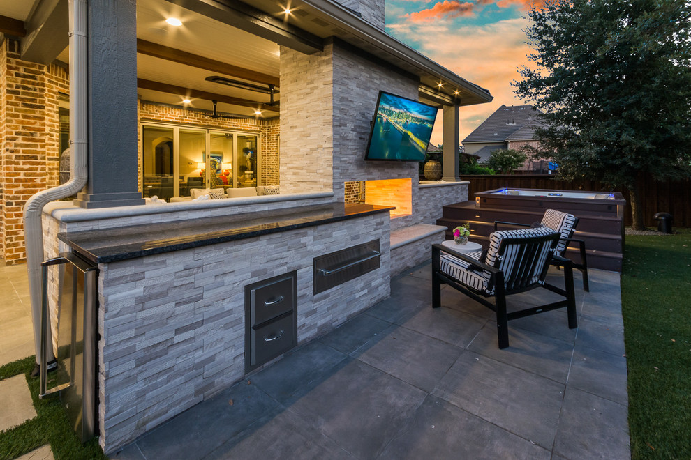 Design ideas for an expansive transitional backyard patio in Dallas with tile and a roof extension.