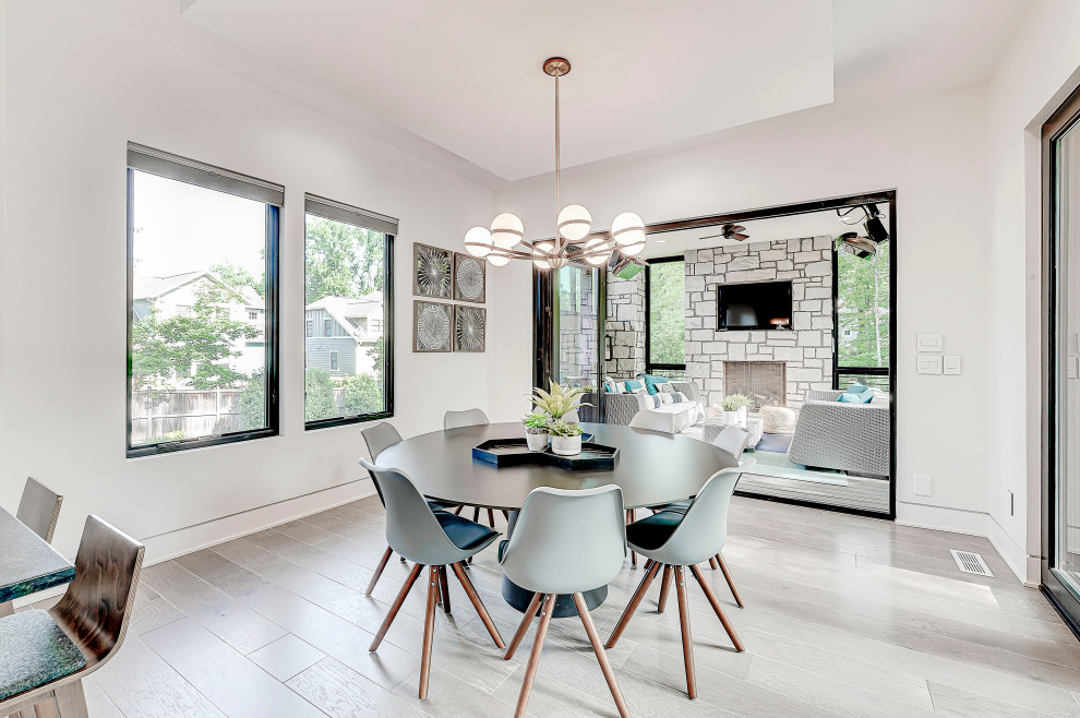 This is an example of a mid-sized contemporary kitchen/dining combo in Indianapolis with white walls, light hardwood floors, no fireplace and grey floor.