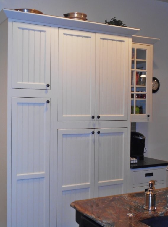 Inspiration for a large transitional u-shaped dark wood floor eat-in kitchen remodel with an undermount sink, recessed-panel cabinets, white cabinets, limestone countertops, beige backsplash, glass tile backsplash, stainless steel appliances and an island