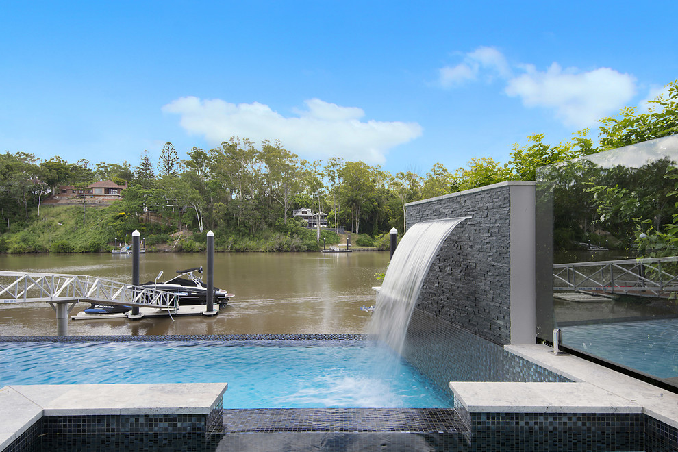 Inspiration for a contemporary backyard custom-shaped pool in Brisbane with decking.