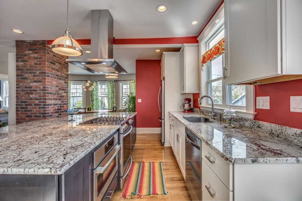 Inspiration for a mid-sized transitional galley light wood floor and beige floor eat-in kitchen remodel in Boston with an undermount sink, shaker cabinets, white cabinets, granite countertops, red backsplash, stainless steel appliances and an island