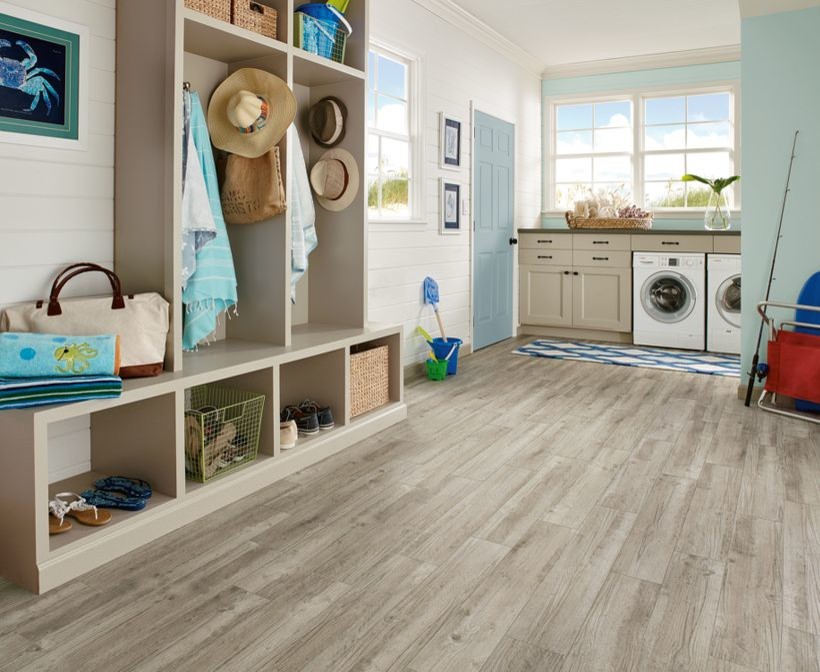 Photo of a large beach style l-shaped utility room in Wichita with beige cabinets, blue walls, vinyl floors, a side-by-side washer and dryer and shaker cabinets.