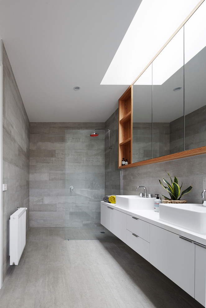 Photo of a mid-sized contemporary 3/4 bathroom in Melbourne with white cabinets, gray tile, cement tile, grey walls, ceramic floors, engineered quartz benchtops, a vessel sink, flat-panel cabinets, an open shower and an open shower.
