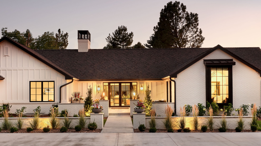 Diseño de fachada de casa blanca y negra clásica renovada de tamaño medio de una planta con revestimientos combinados