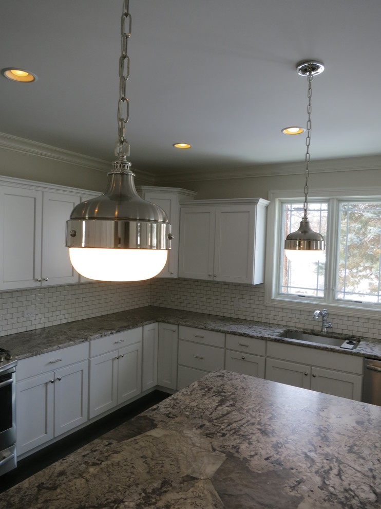 Example of a large transitional u-shaped dark wood floor open concept kitchen design in Chicago with an undermount sink, recessed-panel cabinets, white cabinets, granite countertops, white backsplash, ceramic backsplash, stainless steel appliances and an island