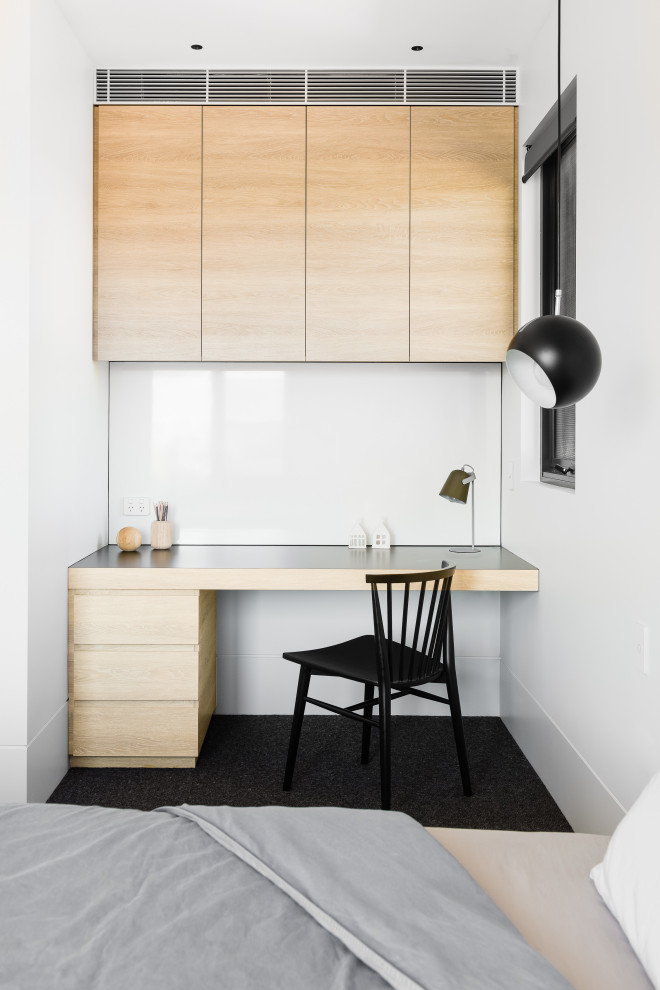 This is an example of a contemporary bedroom in Sydney with white walls and black floor.