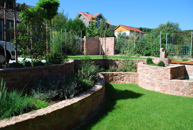 Garten mit Plfanzbeeten aus Sandsteinmauern contemporary-garden