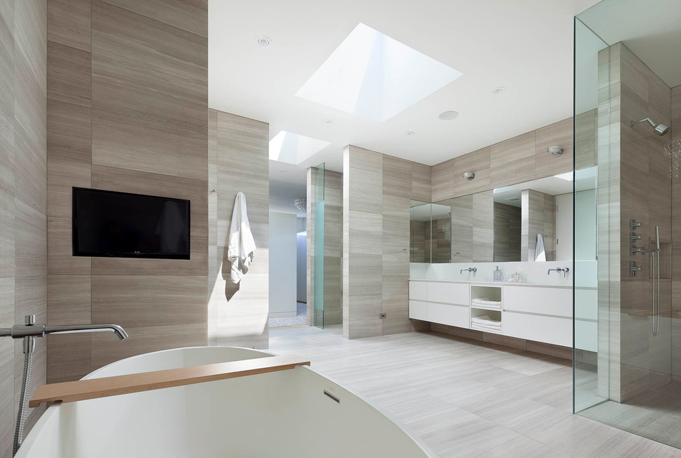 Large modern master bathroom in Toronto with flat-panel cabinets, white cabinets, a freestanding tub, a curbless shower, a one-piece toilet, gray tile, stone tile, grey walls, limestone floors, a trough sink and solid surface benchtops.