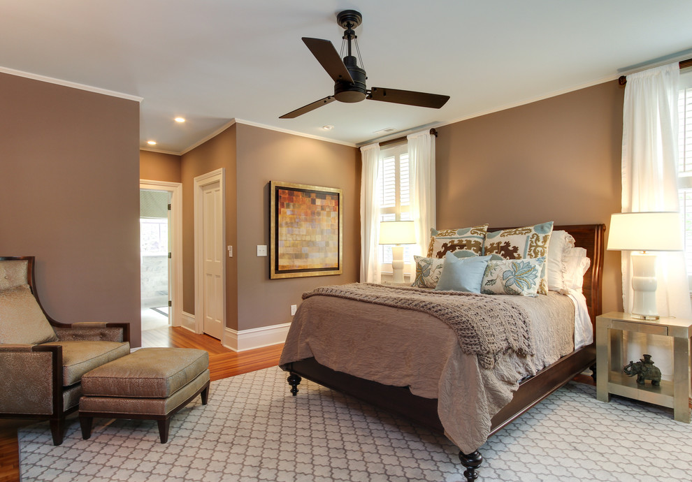 This is an example of a mid-sized traditional master bedroom in Raleigh with brown walls, medium hardwood floors, no fireplace and beige floor.