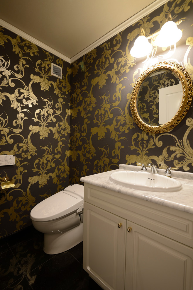 他の地域にあるトラディショナルスタイルのおしゃれなトイレ・洗面所 (落し込みパネル扉のキャビネット、白いキャビネット、マルチカラーの壁、オーバーカウンターシンク、大理石の洗面台) の写真