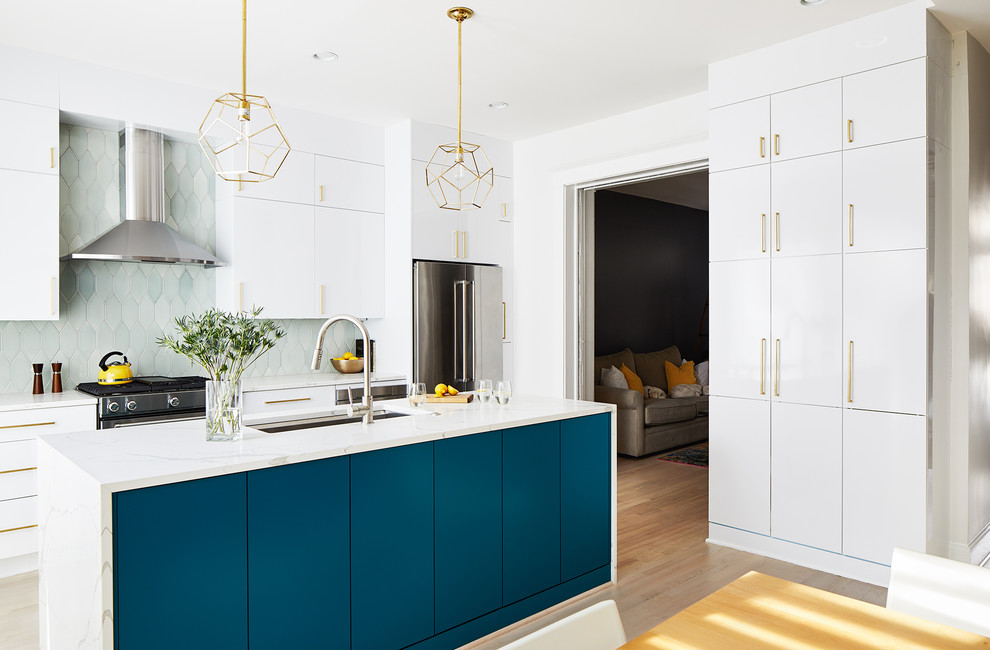 Contemporary kitchen in DC Metro with flat-panel cabinets, turquoise cabinets, green splashback, stainless steel appliances, light hardwood floors, with island and white benchtop.