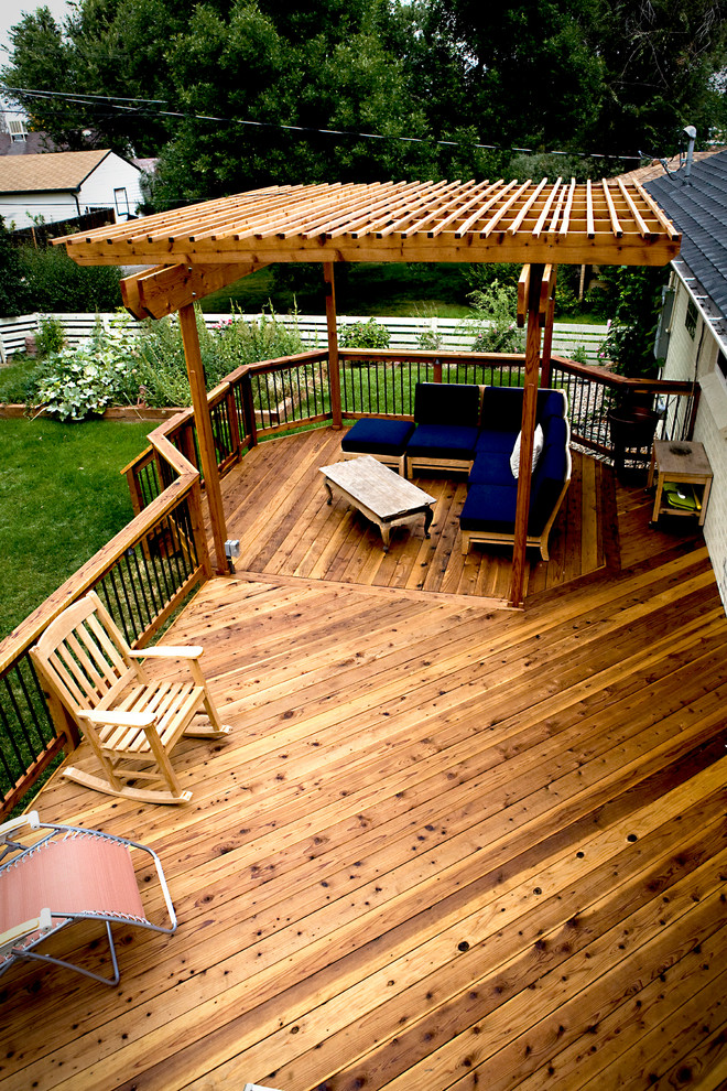 Photo of a mid-sized transitional backyard deck in Denver with a pergola.