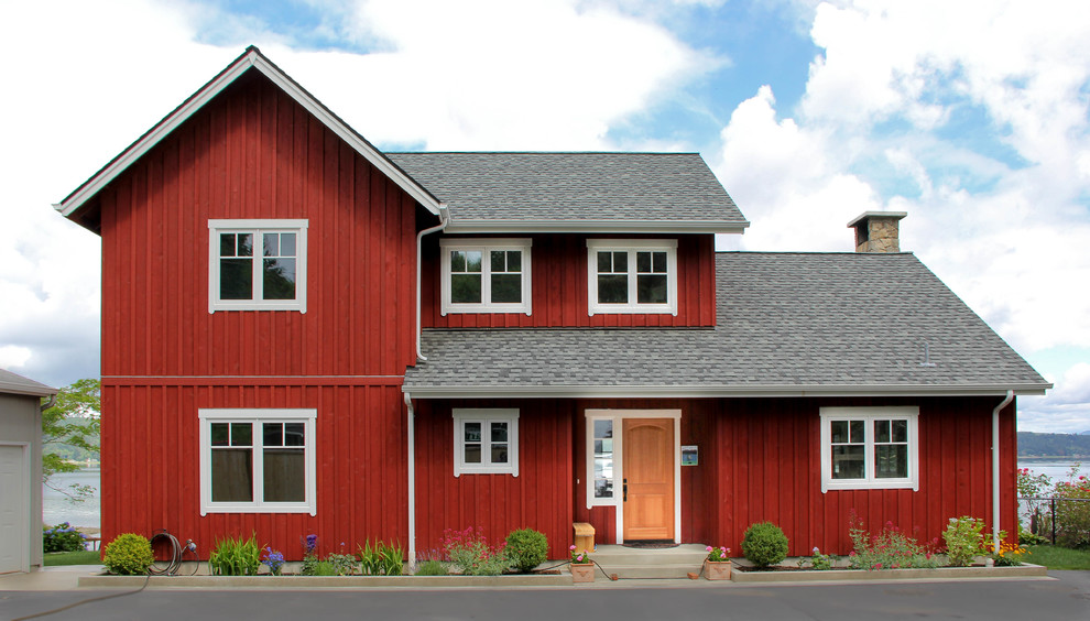This is an example of a mid-sized scandinavian two-storey red exterior in Seattle with wood siding and a gable roof.
