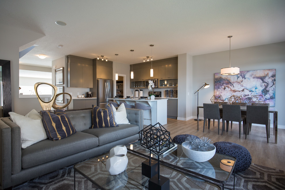 This is an example of a mid-sized contemporary formal living room in Calgary with grey walls, light hardwood floors, a wall-mounted tv, beige floor and no fireplace.