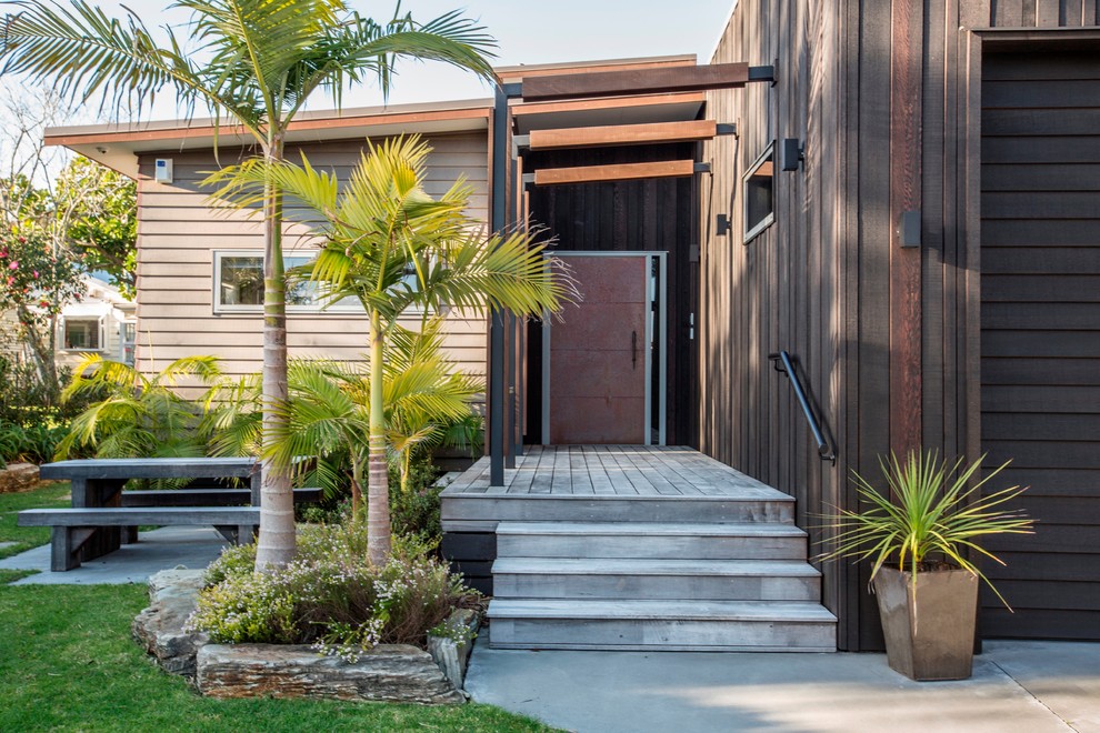 Photo of a large beach style entryway with a single front door and a metal front door.
