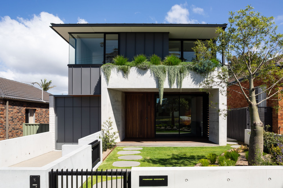 This is an example of a large contemporary two-storey concrete house exterior in Sydney.