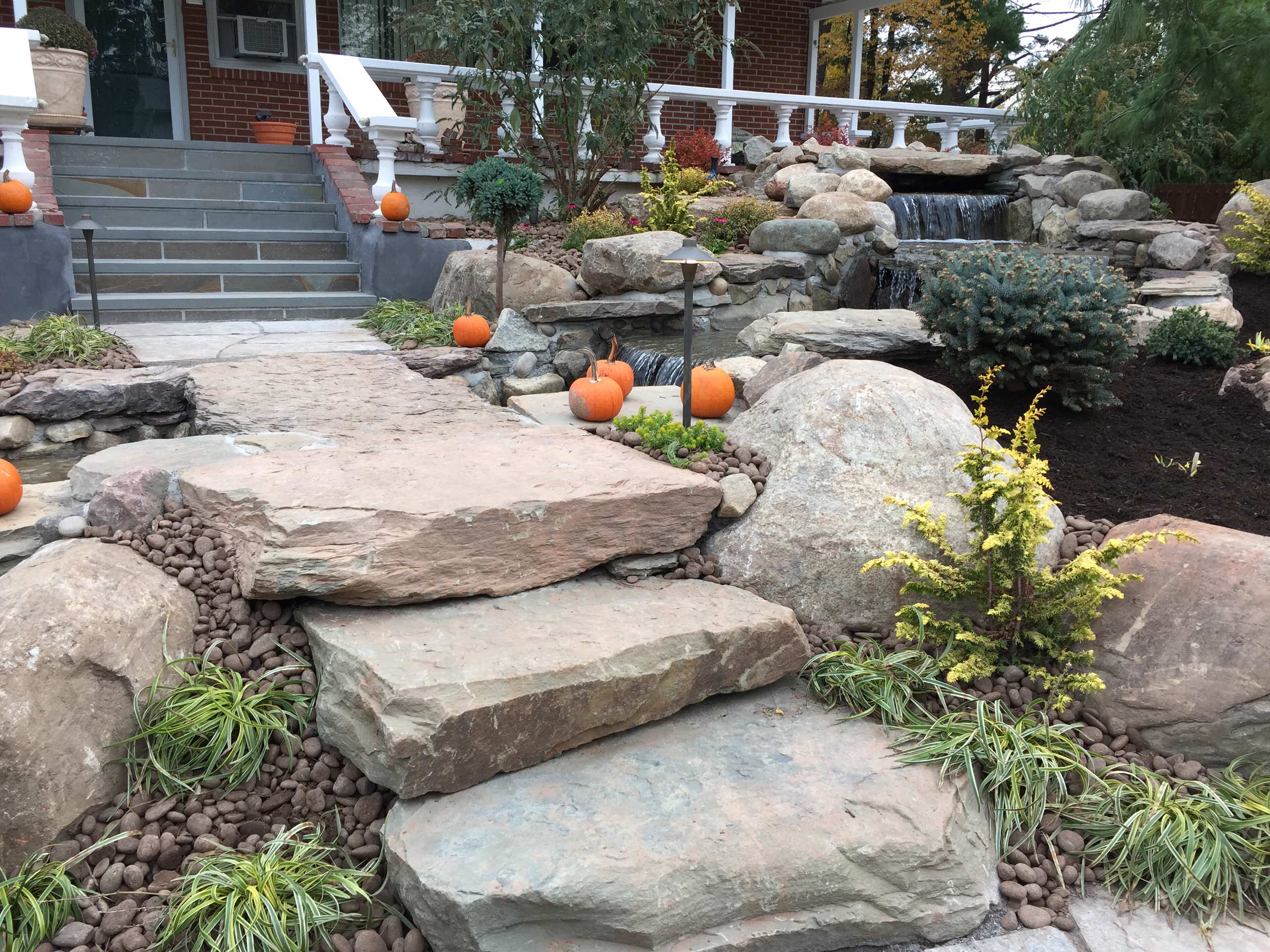 waterfall stream with stone bridge and natural bluestone walkwayway and steps