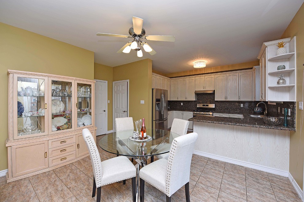Large transitional u-shaped porcelain tile and beige floor open concept kitchen photo in Toronto with an undermount sink, recessed-panel cabinets, white cabinets, granite countertops, brown backsplash, stone slab backsplash, stainless steel appliances and a peninsula