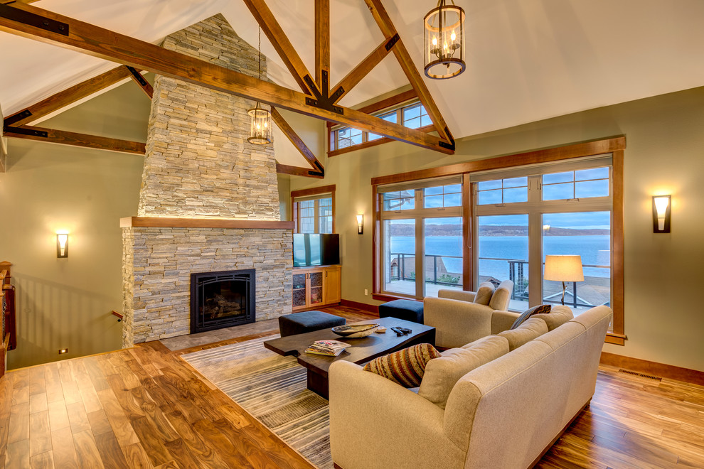 Inspiration for a mid-sized contemporary formal open concept living room in Seattle with beige walls, medium hardwood floors, a standard fireplace, a stone fireplace surround, a freestanding tv and beige floor.