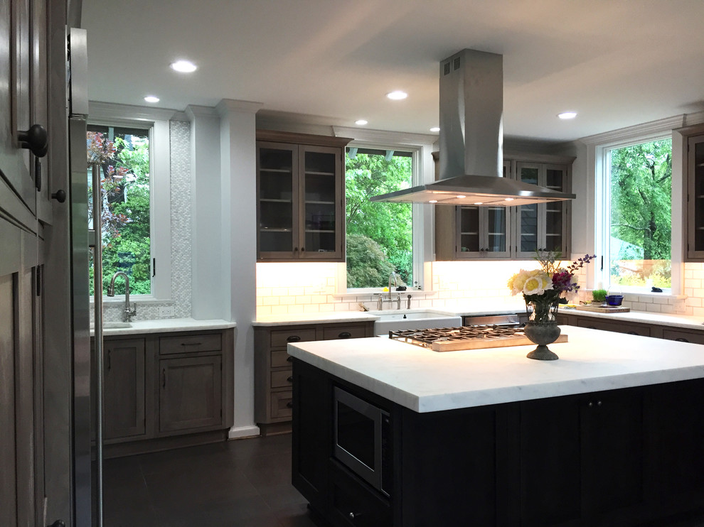Kitchen - transitional ceramic tile and black floor kitchen idea with an undermount sink, shaker cabinets, medium tone wood cabinets, marble countertops, white backsplash, ceramic backsplash, stainless steel appliances and an island
