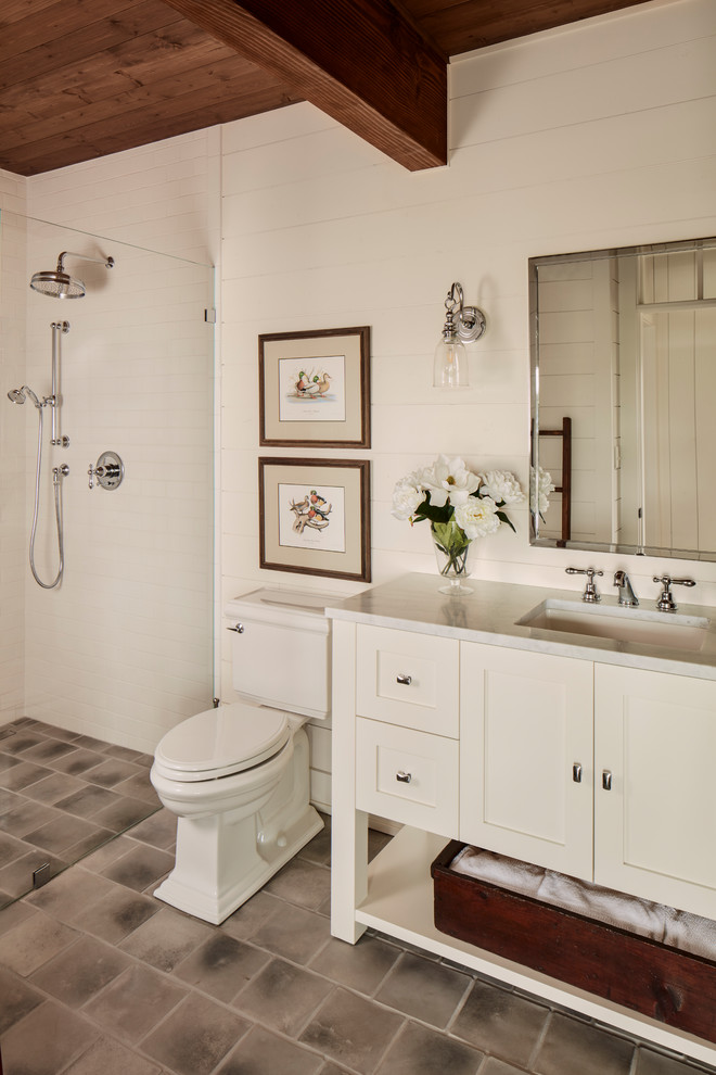 Photo of a country 3/4 bathroom in Milwaukee with shaker cabinets, white cabinets, an alcove shower, a two-piece toilet, white walls, an undermount sink, grey floor and white benchtops.
