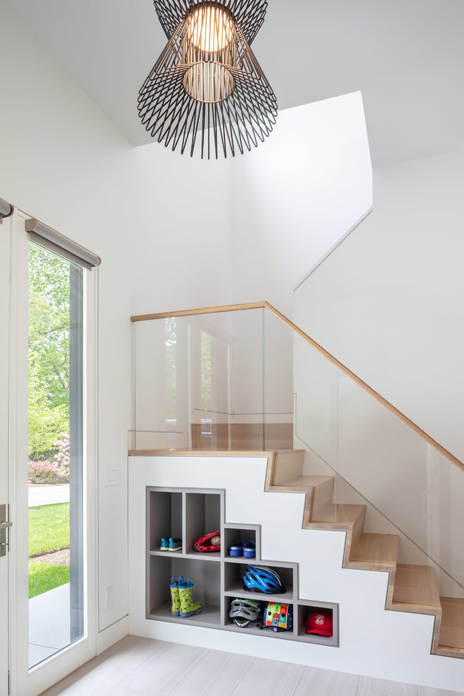 Photo of a large contemporary wood u-shaped staircase in Providence with wood risers and glass railing.