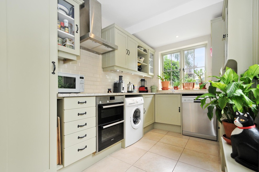 Inspiration for a small beach style galley separate kitchen in Surrey with an undermount sink, shaker cabinets, green cabinets, granite benchtops, beige splashback, ceramic splashback, stainless steel appliances, porcelain floors and beige floor.