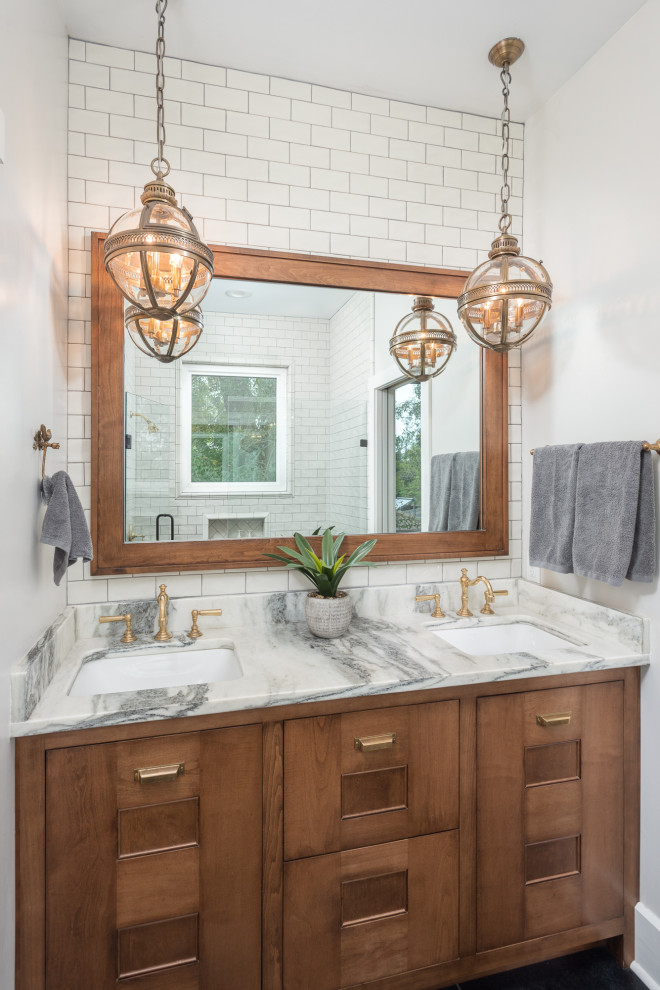 Inspiration for a mid-sized country master bathroom in Tampa with shaker cabinets, medium wood cabinets, a double shower, a one-piece toilet, white tile, subway tile, white walls, slate floors, an undermount sink, marble benchtops, black floor, a hinged shower door, white benchtops, a double vanity and a built-in vanity.