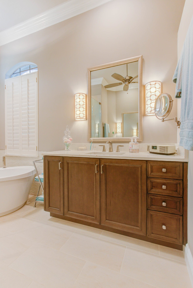 Inspiration for a large traditional master bathroom in Other with furniture-like cabinets, brown cabinets, a freestanding tub and white tile.