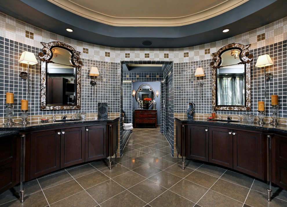 Traditional bathroom in DC Metro with an undermount sink, dark wood cabinets, granite benchtops, a drop-in tub, an alcove shower, a one-piece toilet, blue tile and glass tile.