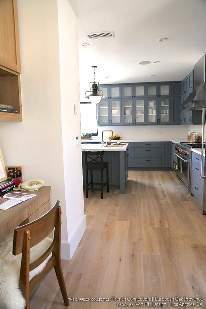 This is an example of a scandinavian kitchen pantry in Los Angeles with shaker cabinets, blue cabinets and light hardwood floors.