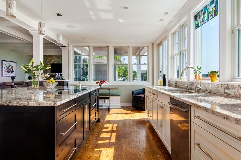 Example of a large transitional l-shaped medium tone wood floor eat-in kitchen design with recessed-panel cabinets, white cabinets, granite countertops, gray backsplash, stainless steel appliances and an island
