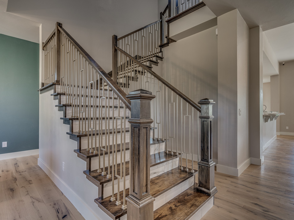 Aménagement d'un escalier courbe campagne de taille moyenne avec des marches en bois, des contremarches en marbre et un garde-corps en bois.