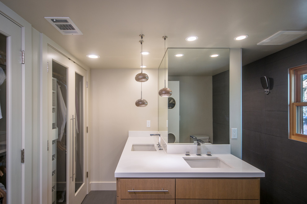 Photo of a small modern master bathroom in Sacramento with an undermount sink, flat-panel cabinets, light wood cabinets, solid surface benchtops, an open shower, a one-piece toilet, gray tile, ceramic tile, beige walls and ceramic floors.