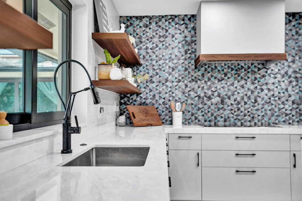 Foto på ett funkis vit kök och matrum, med släta luckor, grå skåp, blått stänkskydd och en köksö