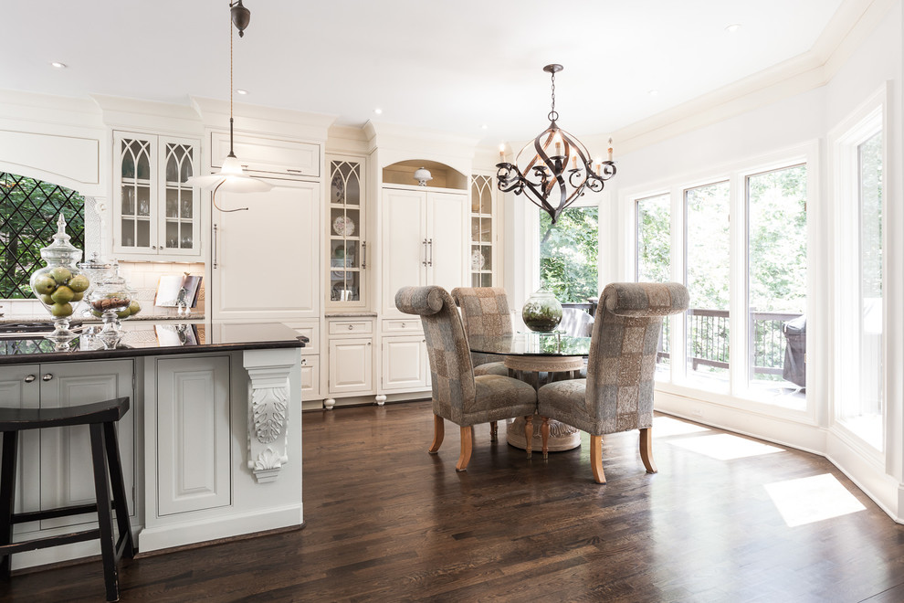 Large transitional l-shaped dark wood floor and brown floor eat-in kitchen photo in Atlanta with an undermount sink, raised-panel cabinets, white cabinets, granite countertops, white backsplash, paneled appliances, an island and brown countertops
