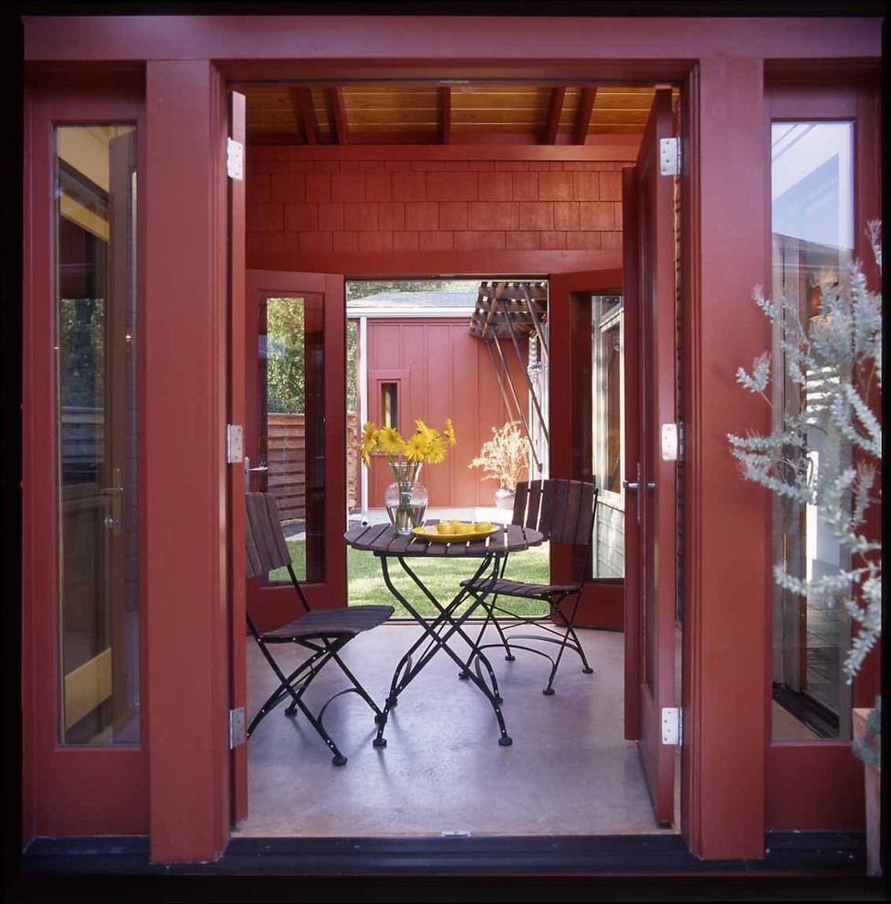 Inspiration for a mid-sized eclectic courtyard patio in Austin with a roof extension and concrete slab.