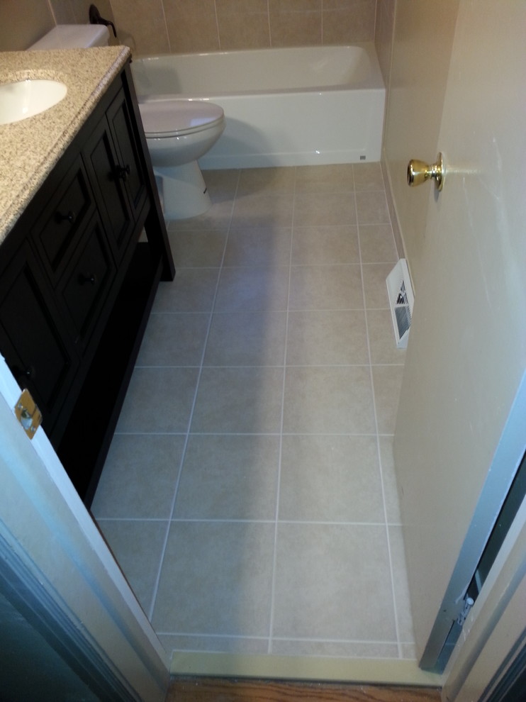 Inspiration for a mid-sized transitional 3/4 porcelain tile and beige floor alcove bathtub remodel with furniture-like cabinets, dark wood cabinets, a two-piece toilet, beige walls, an undermount sink, solid surface countertops and multicolored countertops